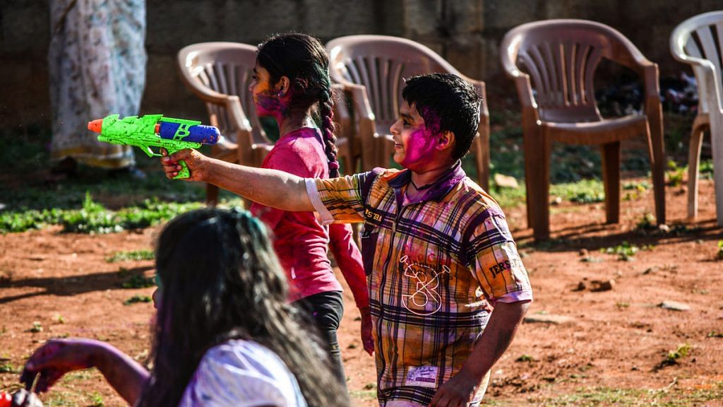 Kids squit water from a toy gun during Holi | Flickr