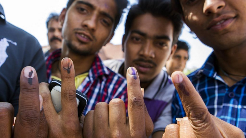 Voters displays their inked fingers for a photograph after casting their votes at a polling station in New Delhi, India, on April 10, 2014|