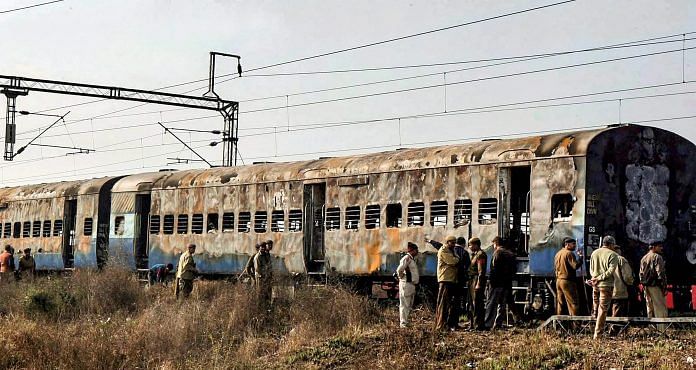 In this Feb 19, 2007 file photo, police inspect the burnt coaches of Samjhauta Express at Deewana village near Panipat