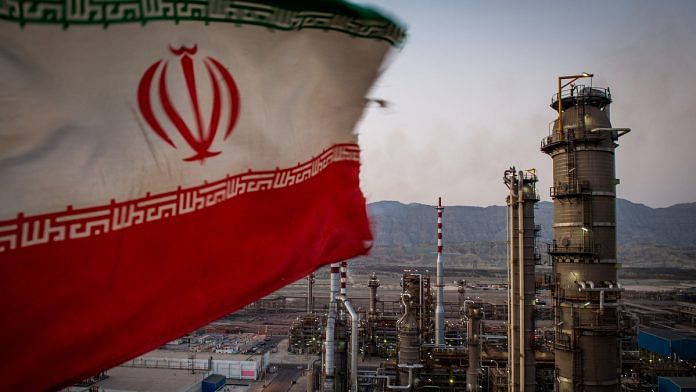 An Iranian national flag flies at the Persian Gulf Star Co. (PGSPC) gas condensate refinery in Bandar Abbas, Iran| Ali Mohammadi/Bloomberg