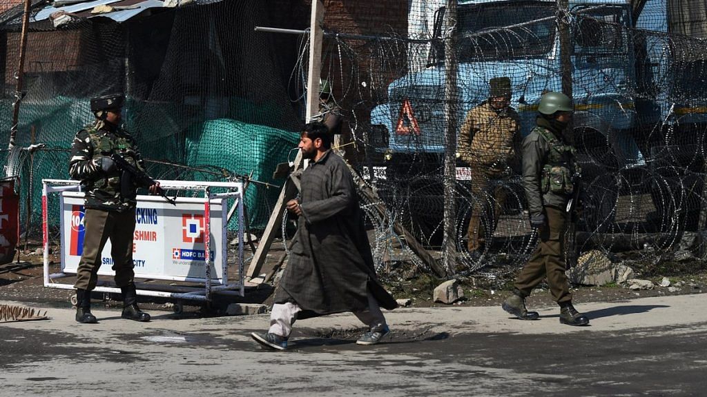 Security personnel guard a street during a strike call given by traders in protest against the extension of Central laws to Jammu and Kashmir and ban on Jamaat-e-Islami