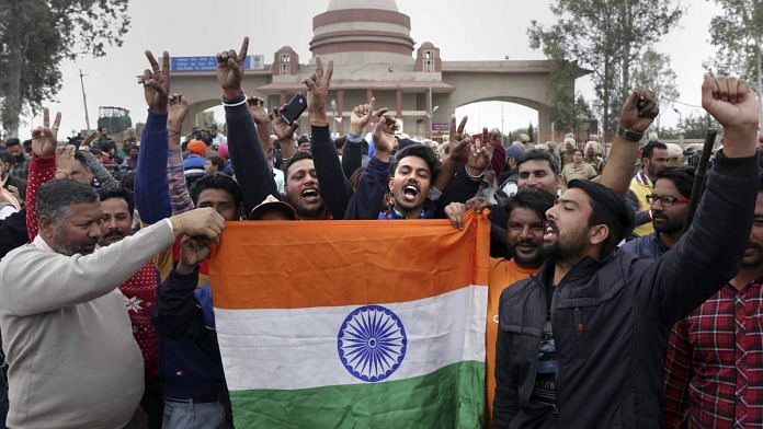 People celebrate with a Tricolour as they wait for the arrival of IAF pilot Wing Commander Abhinandan Varthaman at Attari-Wagah border near Amritsar | PTI photo