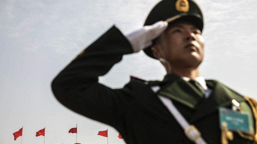 A member of the Chinese People's Armed Police salutes in Tiananmen Square following the first session of the 13th National People's Congress (NPC) in Beijing