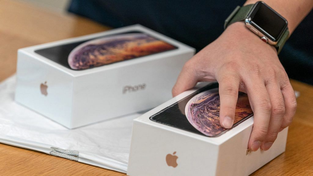An employee holds a box of the Apple Inc. iPhone XS at an Apple store during its launch in Hong Kong, China
