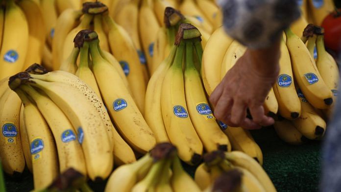 A customer selects a bunch of Chiquita bananas at a fruit and vegetable stall at a market in the Lewisham district of London, U.K