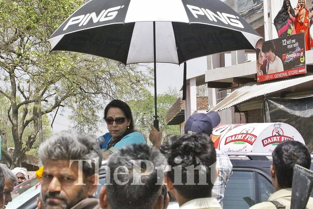 Someone in car behind rushes out with a black umbrella when he sees her vehicle stop and the sun-roof slide| Praveen Jain/ ThePrint 