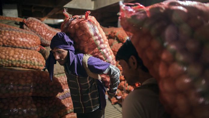 Workers carry sacks of potatoes inside a cold storage unit at the Fryo Foods Pvt factory in Meerut, Uttar Pradesh, India, on Monday