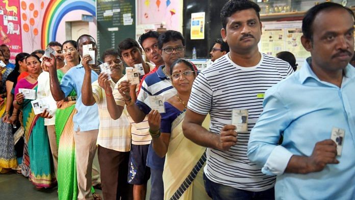 Voters stand in a queue to cast their vote at a polling station in Mumbai