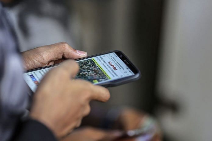 Representational image. A man reads a news article on a smartphone | Dhiraj Singh/Bloomberg