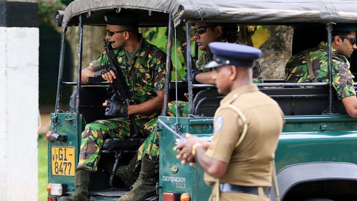 Special Task Force (STF) police officers sit in a vehicle arriving at the Parliament of Sri Lanka in Colombo