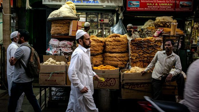 Pedestrians walk past stalls selling food outside the Jama Masjid | Sanjit Das | Bloomberg