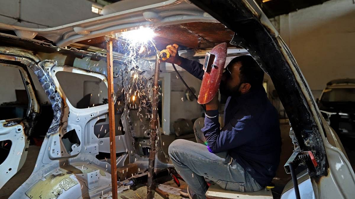 A worker welds armouring to the roof of an SUV at a Laggar Industries factory in Jalandhar, Punjab