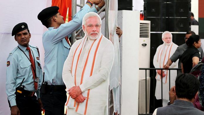 Cardboard cut-outs of Modi are displayed at an even