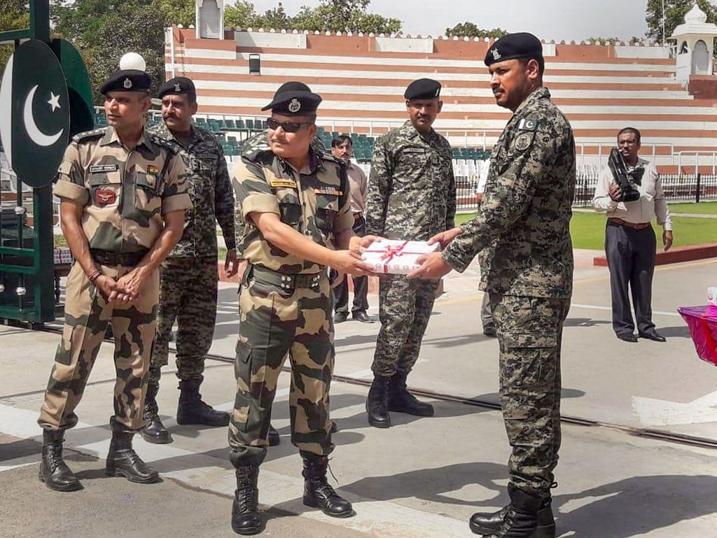 Border Security Force (BSF) exchanges sweets with Pakistani Ranger official on the occasion of Eid-ul-Fitr at the Indo-Pak Wagah Border. | Photo: PTI