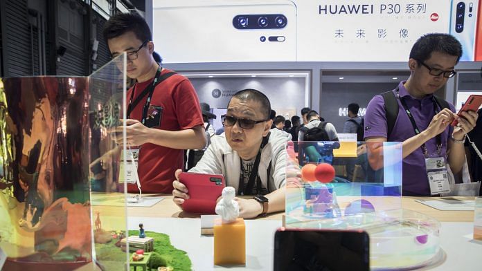Attendees try out Huawei Technologies Co. smartphones on display at the company's exhibition | Qilai Shen- Bloomberg