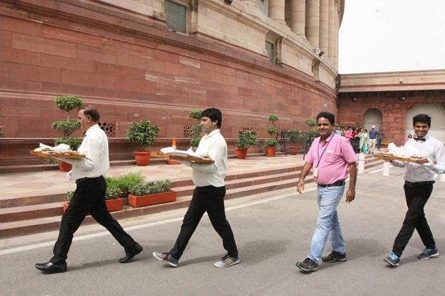 After the event Parliament employees carry food for speaker Om Birla