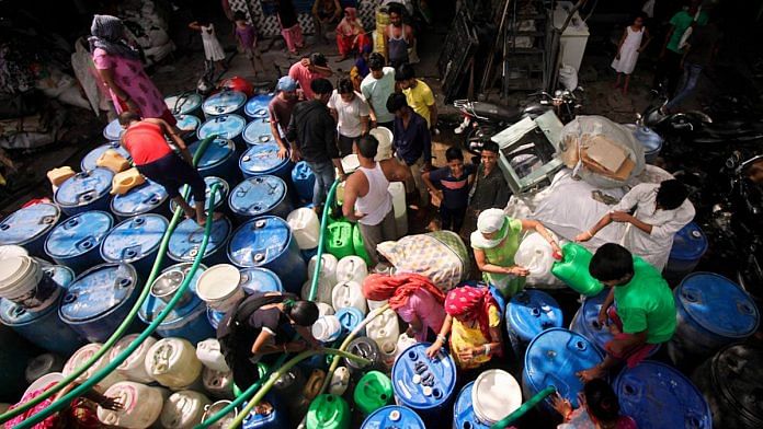 Residents fill empty vessels for drinking from a Delhi Jal Board tanker in New Delhi