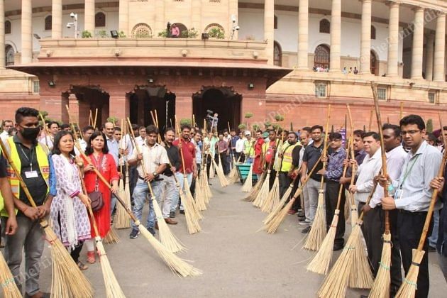 NDMC employees pose with brooms before the event