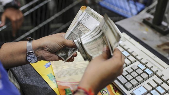 A cashier counts Indian rupee bank notes. | Photographer: Dhiraj Singh | Bloomberg
