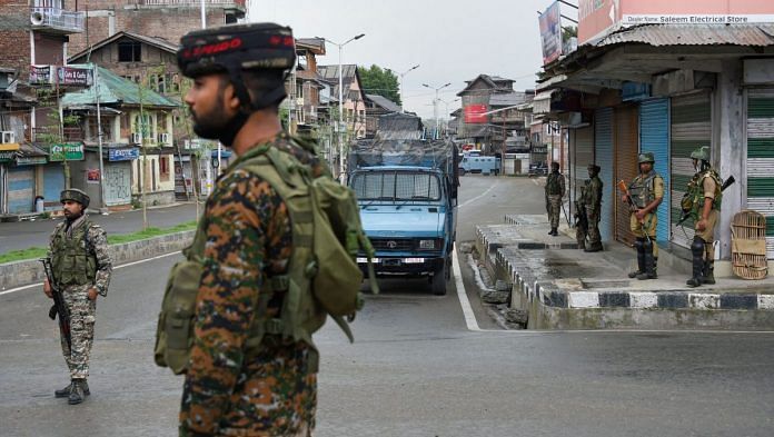 Security personnel stand guard during curfew like restrictions on the fifth consecutive day in Srinagar, Friday, August 9, 2019