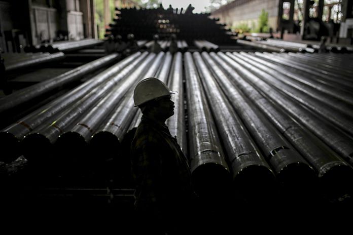 A worker stands in front of steel tubes at the Steel Authority of India Ltd in Rourkela, Odisha | Dhiraj Singh | Bloomberg File photo