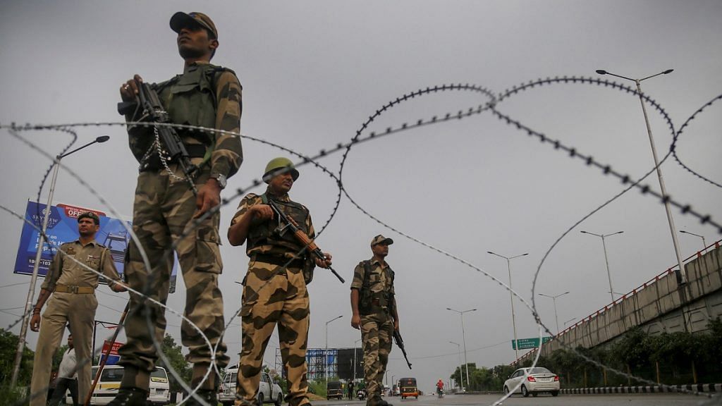 Paramilitary personnel stand guard during restrictions in Jammu