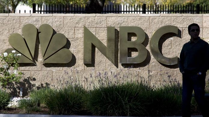 A man walks past an entrance to NBC Studios in Burbank | Photographer: Jonathan Alcorn | Bloomberg