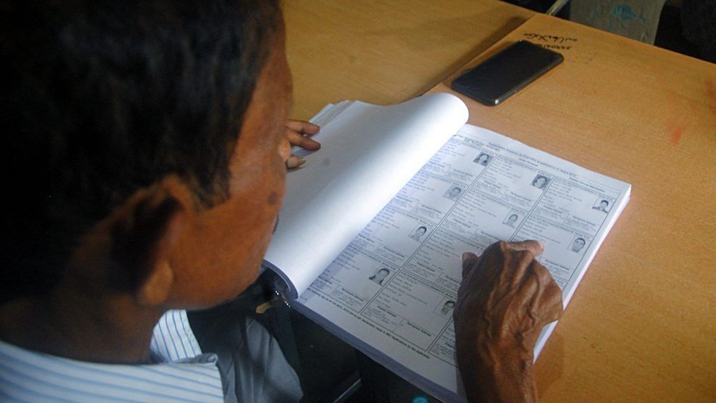 File photo | A man checks his name in NRC list in Guwahati on 31 August 2019 | ANI Photo
