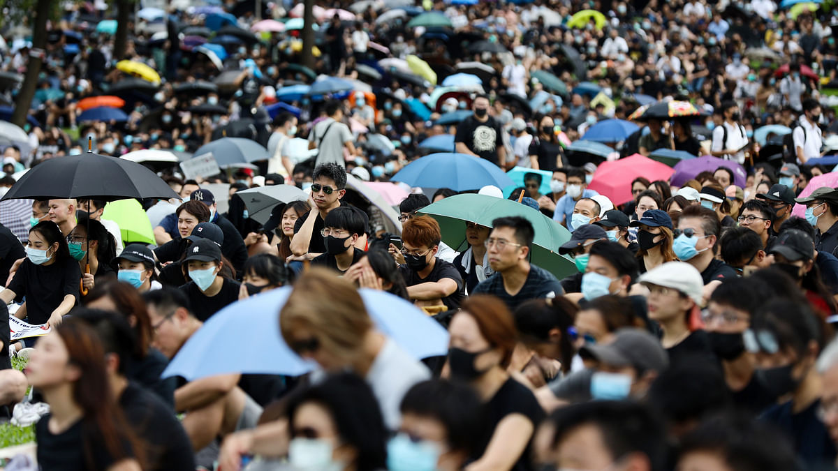 Demonstrators sit during a strike rally at Tamar Park in the Admiralty district of Hong Kong