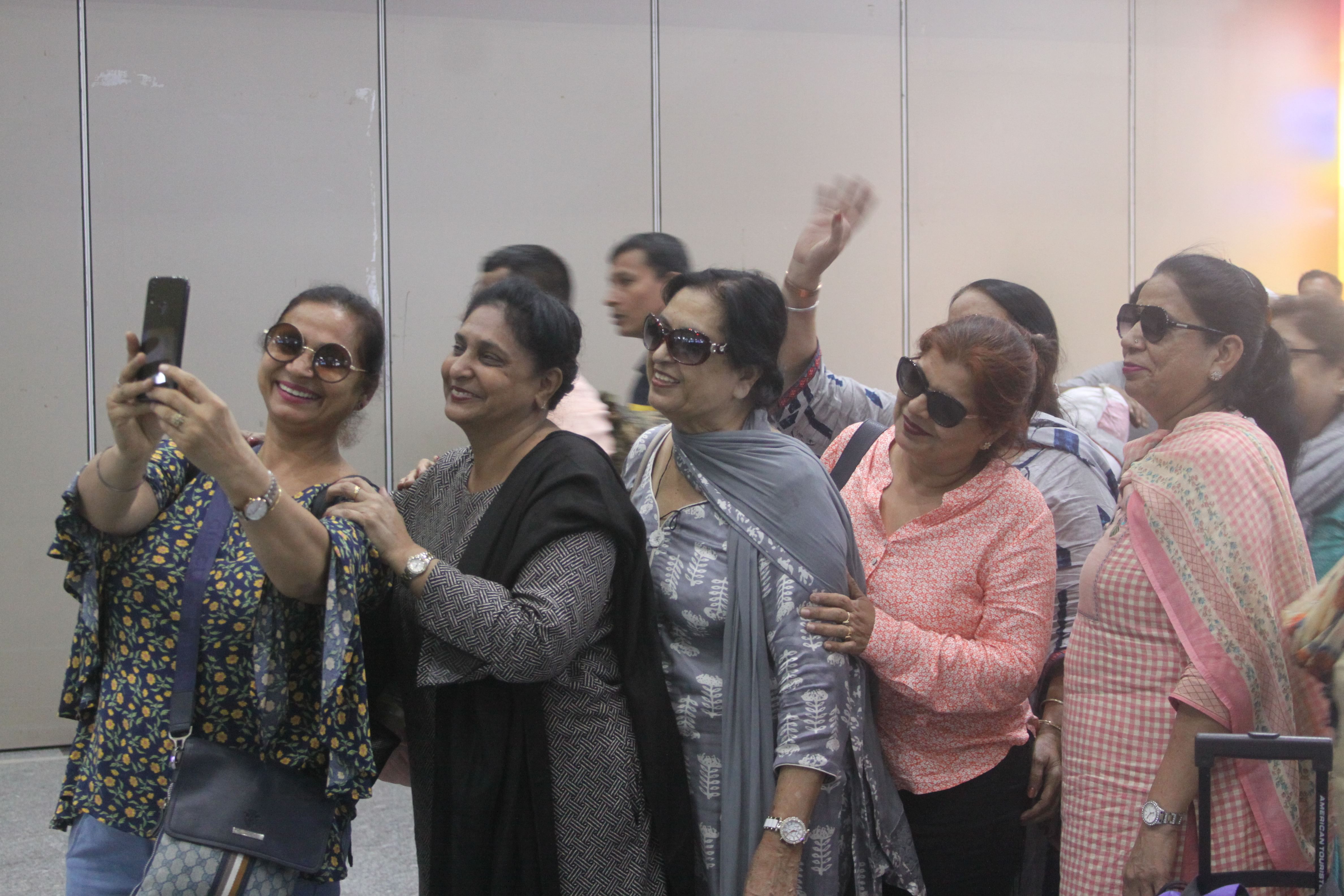 The group of Sikh men and women click selfies on arriving at Srinagar airport | Photo: Praveen Jain | ThePrint