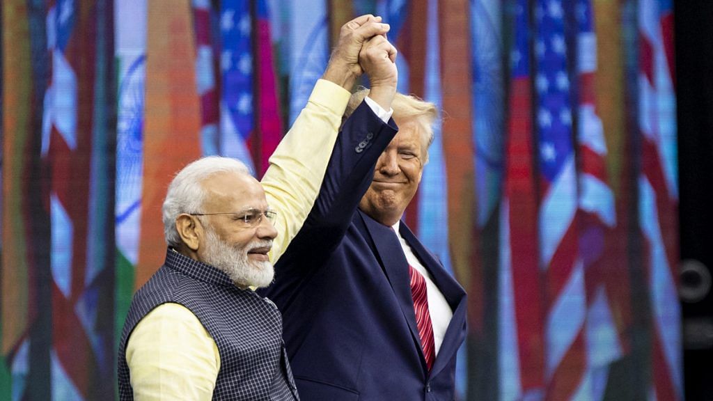 PM Narendra Modi and US President Donald Trump raise hands on stage during the Howdy Modi event in Houston, Texas | Scott Dalton/Bloomberg