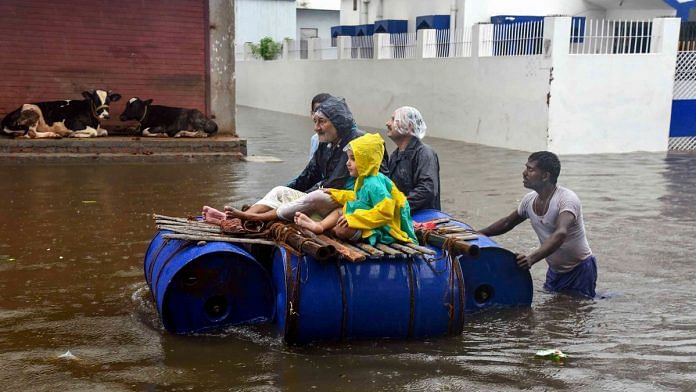Peoples sit on a makeshift boat in Patna on 29 September