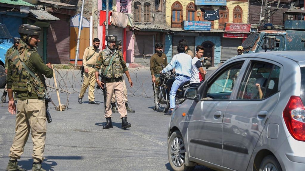 Security personnel divert traffic during curfew like restrictions in Srinagar. | PTI