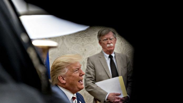 U.S. President Donald Trump, left, speaks as John Bolton, national security adviser, listens during a meeting. | Photographer: Andrew Harrer | Bloomberg