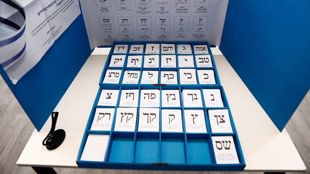 Cards representing the different political parties sit in a booth in a polling station during the election re-run in Rosh Haayin, Israel. | Photographer: Kobi Wolf | Bloomberg