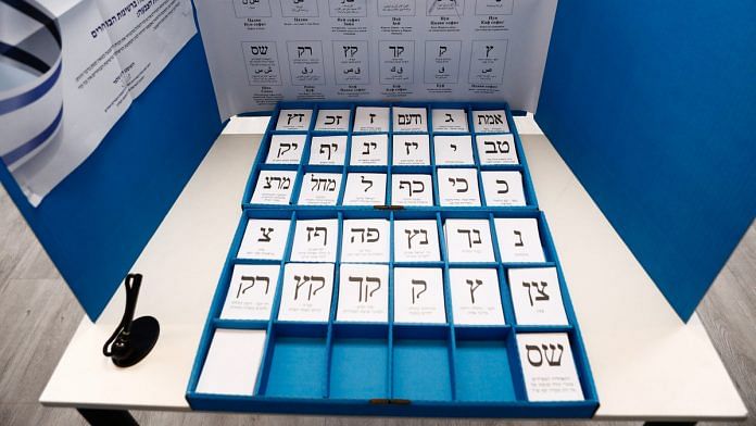 Cards representing the different political parties sit in a booth in a polling station during the election re-run in Rosh Haayin, Israel. | Photographer: Kobi Wolf | Bloomberg
