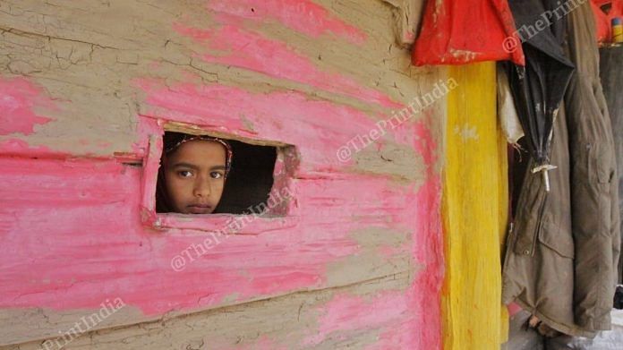 A young girl peers out of her window at Nagin village along the LoC.