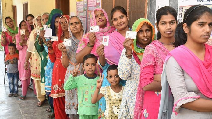 Women stand in a queue to cast their votes at a polling station in Karnal district | PTI