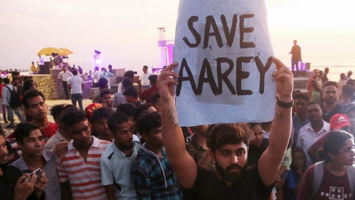 An activist holds a placard during a protest against cutting down of trees at Aarey Colony in Mumbai
