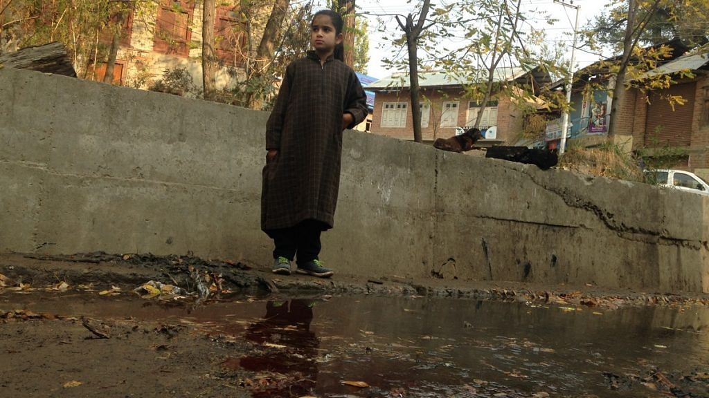 A young girl stands near a pool of blood, after Bengali labourers were killed by militants in Kulgam | Photo: Azaan Javaid