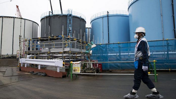 A Tokyo Electric Power Co.'s (TEPCO) employee walks past storage tanks for contaminated water at the company's Fukushima Dai-ichi nuclear power plant in Okuma, Fukushima, Japan | Photo: Tomohiro Ohsumi/Bloomberg