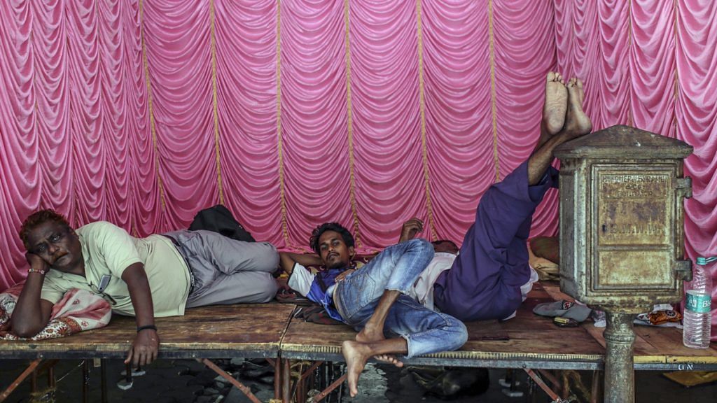 People rest on a temporary stage in Mumbai, India | Representational image | Dhiraj Singh/Bloomberg