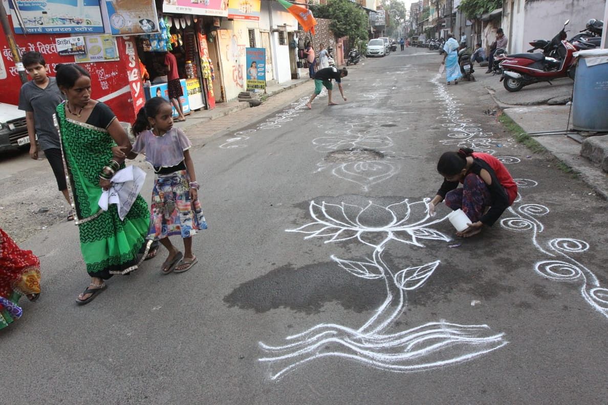 Children can be seen helping prepare the streets of Imamwada in Nagpur with lotus flower rangolis before BJP roadshow