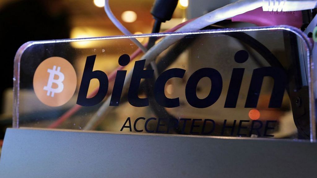 A sign reading "Bitcoin Accepted Here" is displayed next to a cash register at The Pink Cow restaurant and bar in Tokyo, Japan. | Photographer: Yuriko Nakao | Bloomberg