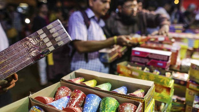 Customers shop for firecrackers and fireworks at a stall during Diwali | Dhiraj Singh/Bloomberg