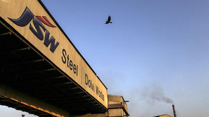 A bird flies above signage for the JSW Steel Ltd. manufacturing facility in Dolvi, Maharashtra. | Photographer: Dhiraj Singh | Bloomberg