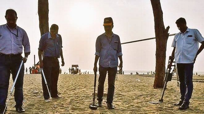 An image, circulating online, shows four security men scanning the beach with bomb detectors, is from 11 April