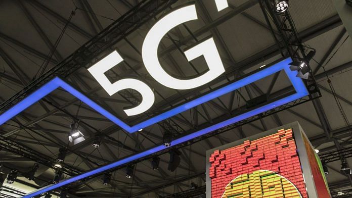 Visitors walks past a large 5G display at a China Unicom booth at the Mobile World Congress in Shanghai