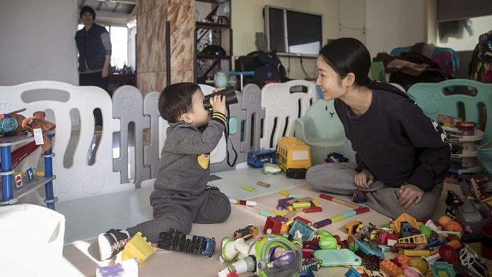 Yiyi and her mother Zhou Xiaoying plays at their home in Shanghai, China | Photo: Qilai Shen/Bloomberg