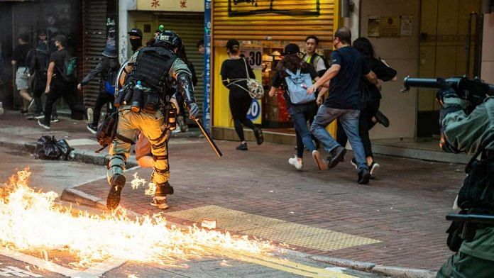 A riot police runs after a petrol bomb lands near his feet during a protest in the Wan Chai district of Hong Kong, China, on 2 November 2019 | Laurel Chor | Bloomberg